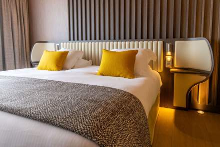 Lit double avec des oreillers jaunes à l'Hôtel de la Paix, Best Western au centre-ville de Reims